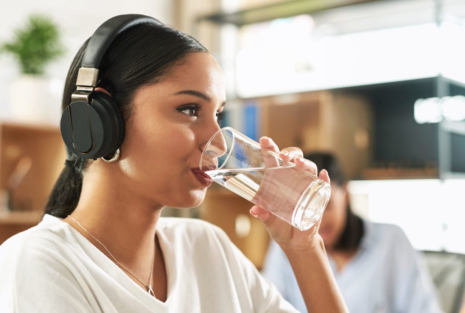woman sat at desk drinking water