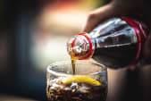 bottle of cola being poured into a glass