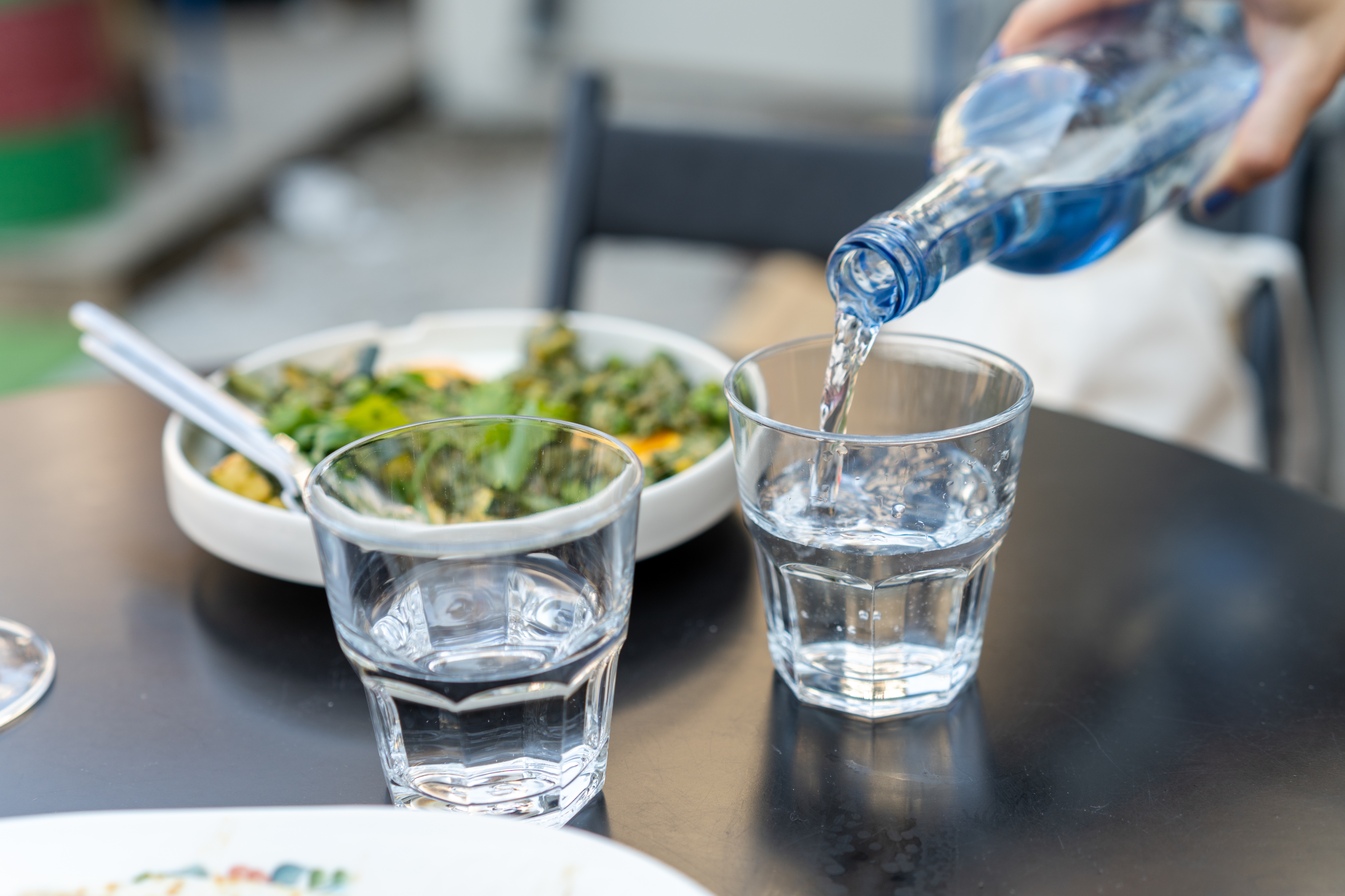 pouring two glasses of water with salad